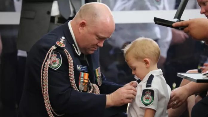 Filho bebê de bombeiro que morreu nos incêndios na Austrália recebe medalha em homenagem ao seu pai