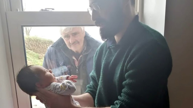 Avô em isolamento conhece o neto recém-nascido pela janela de casa