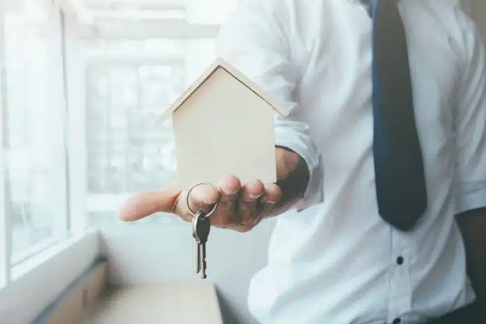 Hand agent with home in palm and key on finger. A rotina de um corretor de imóveis em SP