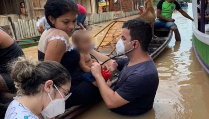 Em meio da cheia de rio, médico atende bebê dentro da água