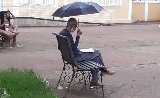 homem Homem é flagrado lendo sozinho na chuva e viraliza nas redes