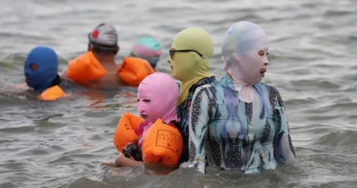 Tendência bizarra? Por que banhistas chineses estão usando máscaras faciais para ir à praia